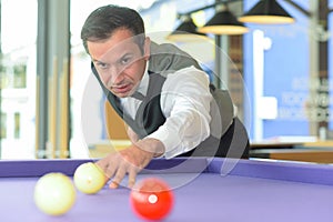 Man playing billiard in pool hall