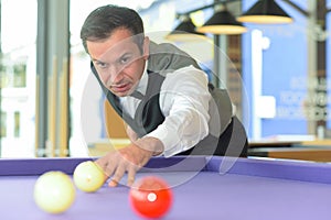 Man playing billiard in pool hall