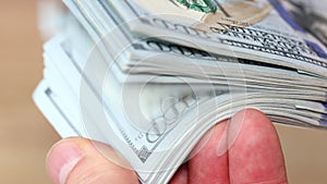 Man playing with a bundle of American dollars, Hundred dollar banknotes, Financial concept