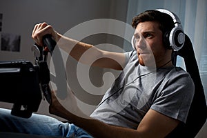 Man playing car racing video game at home