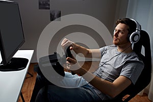 Man playing car racing video game at home