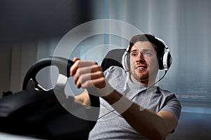 Man playing car racing video game at home