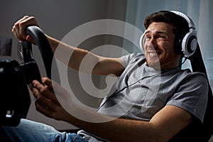 Man playing car racing video game at home