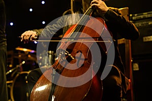 Man playing on cello on stage during concert