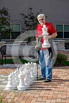 Man playing chess with a outdoor chess set