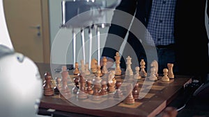 Man playing chess with a robot chessplayer.