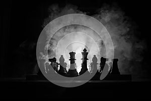 Man playing chess. Scary blurred silhouette of a person at the chessboard with chess figures. Dark toned foggy background.