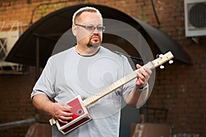 Man playing cigar box guitar