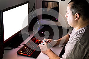 Man playing computer game on custom made desktop with joypad, ke