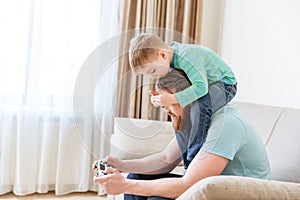 Man playing computer games while little son covering his eyes