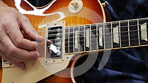 Man playing on electric guitar. Close up view of male fingers on guitar playing solo. Professional guitarist performing lyric song
