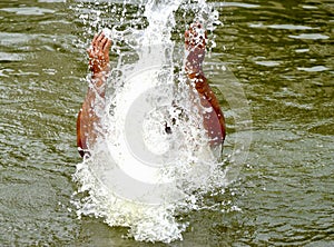 Man playing and enjoying with water in a pond