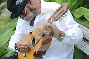 A man playing a folk song in the Puerto Rican Cuatro