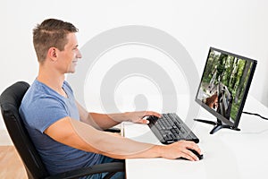 Man Playing Game On Desktop Computer