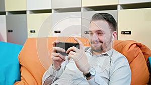 Man playing games on the smartphone indoors