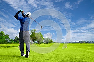 Man playing golf on a golf course in the sun, Golfers hit sweeping golf course in the summer