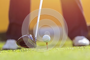 A man playing golf in green course. Focus on golf ball