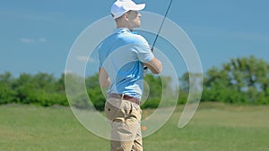 Man playing golf, making long-distance shot with driver on fairway, leisure