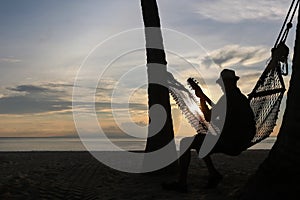 Man playing guitar on the beach with sunset