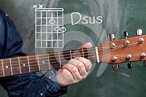 Man playing guitar chords displayed on a blackboard, Chord Dsus