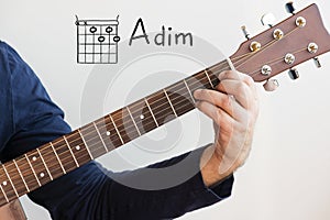 Man playing guitar chords displayed on Whiteboard, Chord A dim