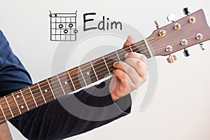 Man playing guitar chords displayed on Whiteboard, Chord E dim