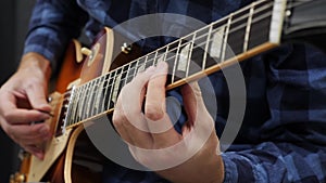 Man playing on guitar. Fingers on guitar fretboard playing chords and solo. Musical instruments concept. Professional guitar lesso