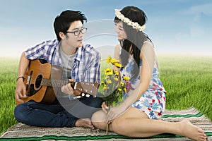 Man playing guitar for his girlfriend