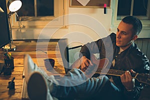 Man playing guitar at home after work