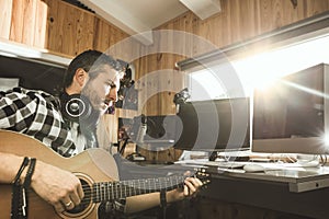 Man playing guitar in a recording studio. Concept guitarist composing music