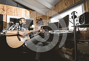 Man playing guitar in a recording studio. Concept guitarist composing music