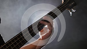 Man playing on guitar a rock concert. Bass guitar closeup