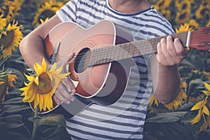 Man playing guitar in sunflower field