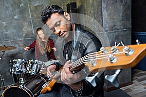 Man playing guitar with woman playing drums, rock and roll band concept