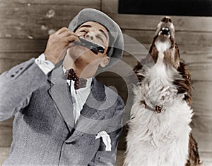 Man playing harmonica with howling dog