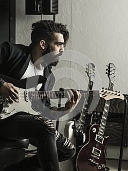 Man playing his electric guitar in a music studio