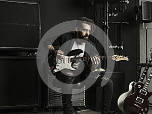 Man playing his electric guitar in a music studio