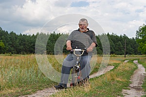 Man playing with kids bicycle