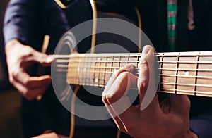 Man playing music at black wooden acoustic guitar photo