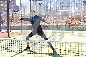 Man playing paddle tennis. Jumping and shooting the ball.