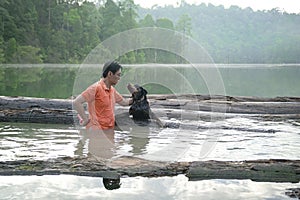 Man playing with pet dog in the lake