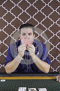 A man playing poker sitting at a table