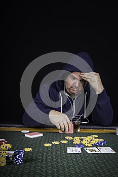 A man playing poker sitting at a table