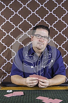 A man playing poker sitting at a table