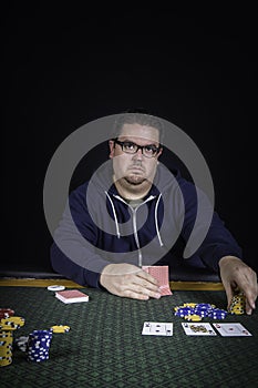 A man playing poker sitting at a table