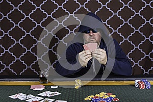 A man playing poker sitting at a table