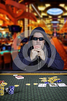 A man playing poker sitting at a table