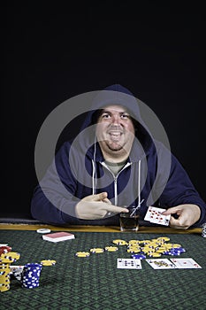 A man playing poker sitting at a table bluffing