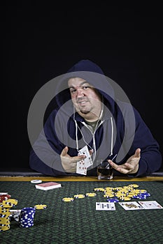 A man playing poker sitting at a table bluffing