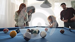 Man playing pool with friends in game room at home